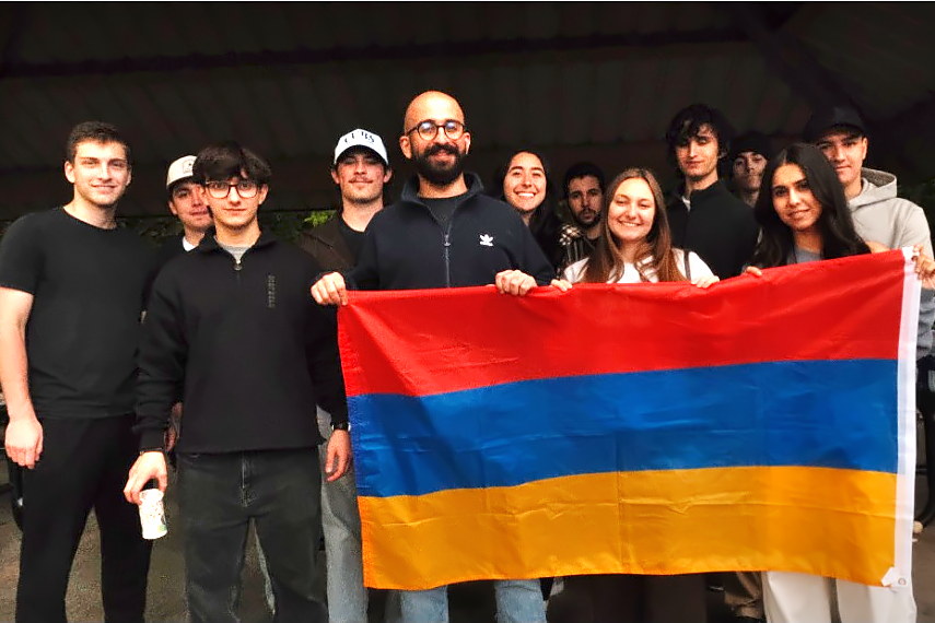 Members of the Armenian Club of Purdue holding an Armenian flag at a park cookout